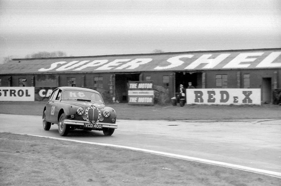 JaguarMichael Parkes seeking some adhesion around Woodcote in his Equipe Endeavour Jaguar...  Goodwood Saloon Cars GPL