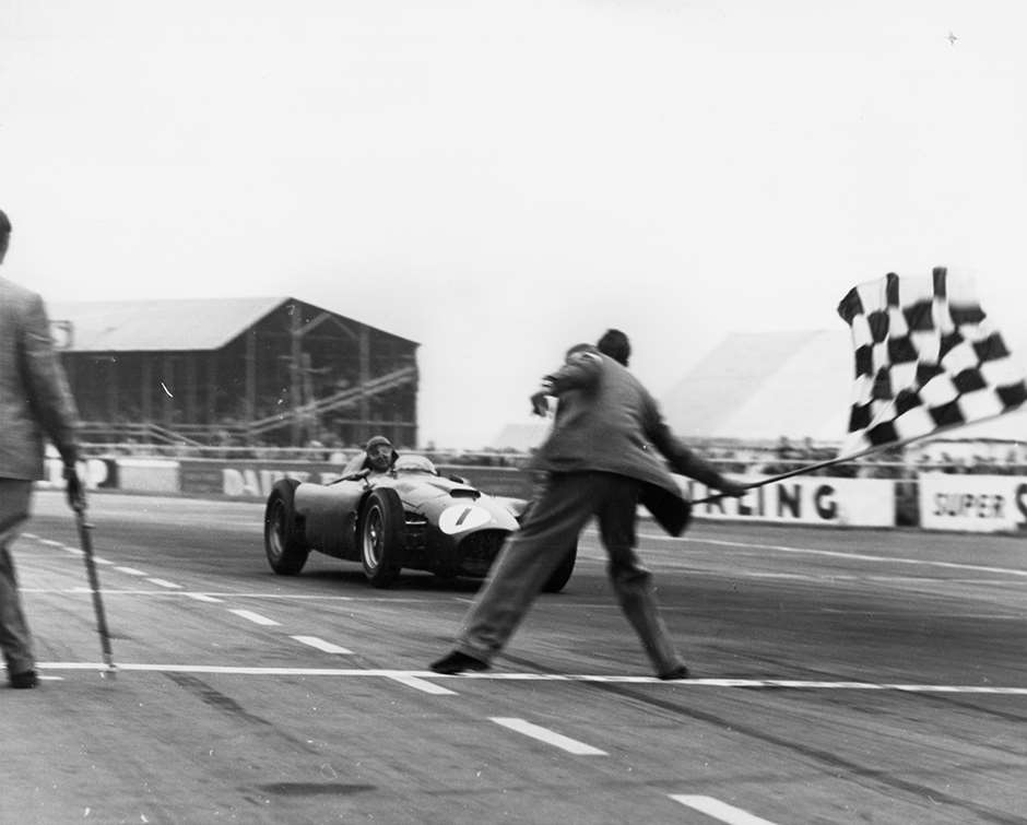 Success! 1956 British GP - unfit Fangio takes the flag in his Lancia-Ferrari D50A GPL