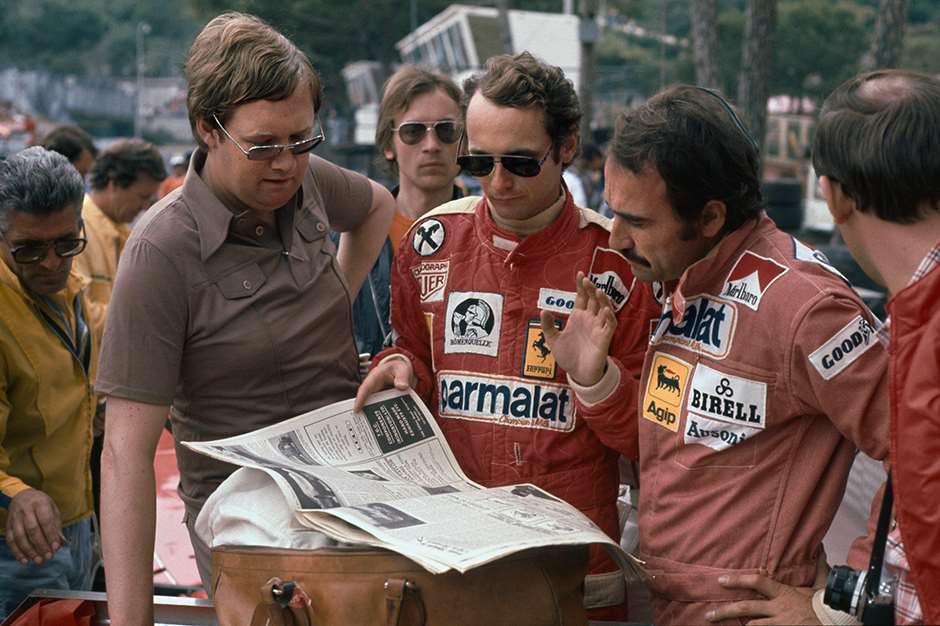 Monte Carlo, Monaco. 27th - 30th May 1976. Journalist Alan Henry with Ferrari drivers Niki Lauda and Clay Regazzoni and a copy of Motoring News, portrait. World Copyright: LAT Photographic. Ref: 76 MON 78.